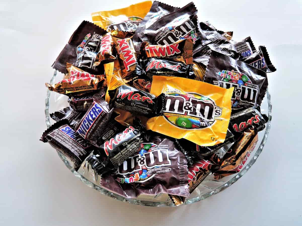 Glass bowl full of candy and chocolate bars